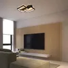 A modern living room with a large TV mounted on a slatted wooden wall, a sleek entertainment unit, and a contemporary ceiling light. Produktbild-Vorschau