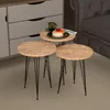 A set of three round nesting tables with wooden tops and black metal legs are arranged on a carpeted floor next to a sofa and a dresser. One of the tables has pancakes and a cup of coffee on it. Podgląd zdjęcia produktu