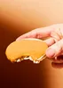 A hand holding a bitten cookie with peanut butter. Produktbild-Vorschau
