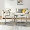 Two round coffee tables with marble tops and silver metal frames are placed in front of a sofa. Voir les images du produit