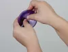 Hands holding and manipulating a purple glitter ball. Produktbild-Vorschau