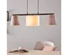 A pendant light fixture hangs over a dining table with a book and a pillow on it. Anteprima dell’immagine prodotto