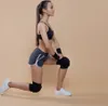 A woman is performing a lunge exercise while wearing knee pads and wristbands. Voir les images du produit