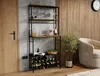 A wine rack filled with wine bottles and glasses in a room with a wooden accent wall and a chair. Podgląd zdjęcia produktu