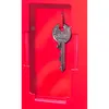 A key is hanging on a red holder. Anteprima dell’immagine prodotto