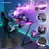 A gaming setup featuring a desk, chair, computer, and accessories, illuminated by LED lights. Produktbild-Vorschau