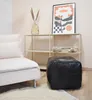 A living room scene with a couch, a shelf, a pouf, and artwork. Podgląd zdjęcia produktu