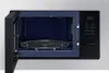 An open microwave with a turntable inside. Produktbild-Vorschau