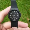 A hand holding a black Casio watch with a green grassy background. Produktbild-Vorschau