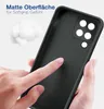 A hand is touching the back of a black phone case, highlighting its matte surface and soft grip texture. There is also a small pile of fluffy white material in the background. Produktbild-Vorschau