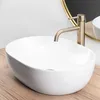A white vessel sink with a gold faucet on a wooden countertop. Anteprima dell’immagine prodotto