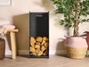 A black metal log holder filled with firewood is placed next to a potted plant and a wooden bench with folded blankets. Anteprima dell’immagine prodotto