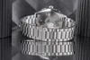 A close-up shot of a watch with its reflection on a mirrored surface. Produktbild-Vorschau