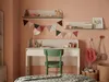 A child's desk area with a chair, shelves, and decorative items. Produktbild-Vorschau