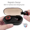 A hand is holding a wireless earbud near its charging case, which is open. Náhled obrázku produktu