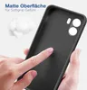 A hand is touching the matte surface of a black phone case, with a small fluffy white object in the background. Produktbild-Vorschau