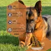 A German Shepherd dog is chewing on a large bone-like treat in a grassy outdoor setting. Produktbild-Vorschau