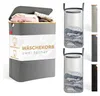A product shot of a grey laundry basket with a bamboo lid, filled with laundry. Several other laundry baskets are shown on the right side of the image. Produktbild-Vorschau