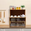 A wooden storage cabinet on a countertop with kitchen utensils hanging on the left. Náhled obrázku produktu