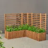 A wooden planter with plants on a paved patio. Anteprima dell’immagine prodotto