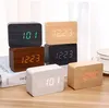 Several digital alarm clocks with wooden casings are displayed on a table. Produktbild-Vorschau