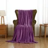 A purple fleece blanket draped over a leather armchair in a well-lit room with sheer curtains in the background. Produktbild-Vorschau
