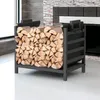 A black metal firewood rack filled with logs, placed indoors near a fireplace. Náhľad obrázku produktu