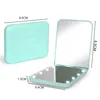 A closed and open compact mirror with LED lights, showing dimensions. Produktbild-Vorschau