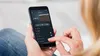 A person is holding a smartphone with a whirlpool app open. Produktbild-Vorschau