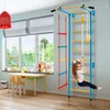 A young girl is climbing on a metal gym set in a room with a large window. Produktbild-Vorschau