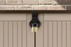 A close-up shot of a locked garden box with a brick wall in the background. Voir les images du produit