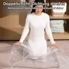 A woman is sitting inside a large, clear vacuum storage bag. Produktbild-Vorschau