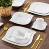 A table setting with white porcelain dishes and gold cutlery. Produktbild-Vorschau