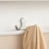 A silver double hook on a white wall, with a tan fabric draped over it. Produktbild-Vorschau