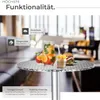 A round aluminum table with drinks and food on it, set in a restaurant or cafe environment. Produktbild-Vorschau