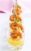 A close-up shot of shrimp appetizers served in small glasses with a yellow sauce. Podgląd zdjęcia produktu