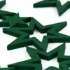 A close-up view of several dark green wooden star-shaped decorations scattered on a white surface. Produktbild-Vorschau