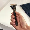 A hand holding a Gillette Fusion 5 ProGlide razor. Anteprima dell’immagine prodotto