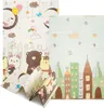 A folded baby play mat with cartoon animal and city designs. Produktbild-Vorschau