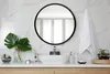 A bathroom vanity with a sink, mirror, and decorative items. Produktbild-Vorschau