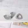 Two metal accessories are placed on a white fabric surface. Produktbild-Vorschau