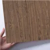 Braunes Holzmaserungs-Kontaktpapier, von einer Hand vor weißem Hintergrund gehalten Náhľad obrázku produktu