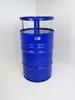 A blue barrel-shaped table with a glass top and a metal rim, standing in a corner against a white wall. Produktbild-Vorschau