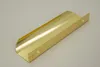 A single, metallic gold furniture handle is shown on a light gray background. Produktbild-Vorschau
