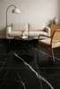 A living room scene with a sofa, coffee table, and chair on a black marble tiled floor. Podgląd zdjęcia produktu