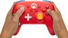 Hands holding a red Nintendo Switch controller with Mario branding. Anteprima dell’immagine prodotto