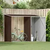 A garden shed with a bicycle and gardening tools inside, set against a wooden fence and green grass. Produktbild-Vorschau