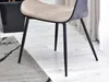A close-up view of the legs and seat of a modern chair, placed on a rug and wooden floor. Podgląd zdjęcia produktu