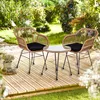 A rattan bistro set with two chairs and a small table on a wooden deck in a garden setting. Podgląd zdjęcia produktu
