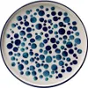 A top-down view of a ceramic plate with a blue polka dot pattern. Voir les images du produit